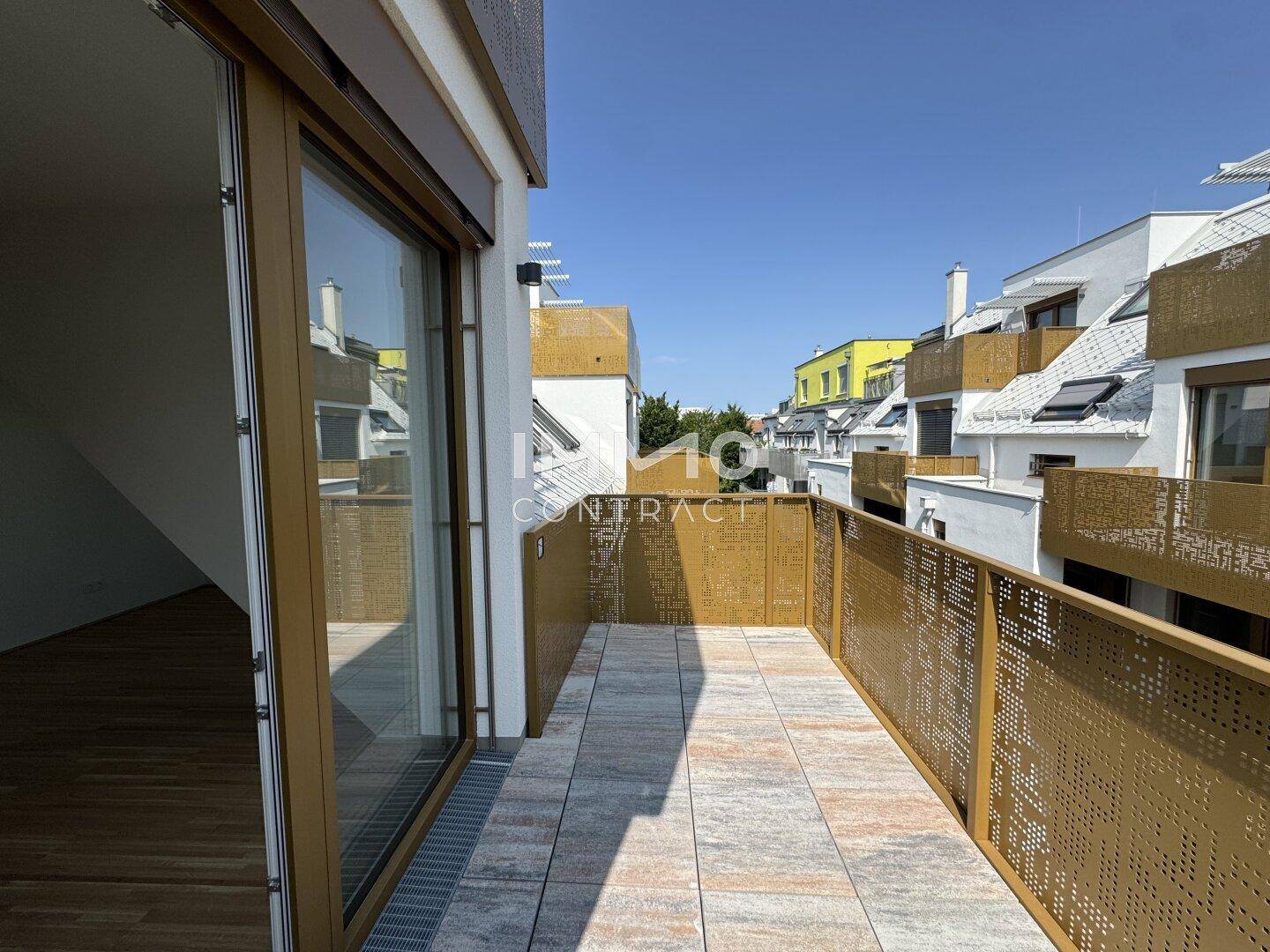 Langer Balkon mit moderner Metallbrüstung und Blick auf die umliegenden Neubauten.