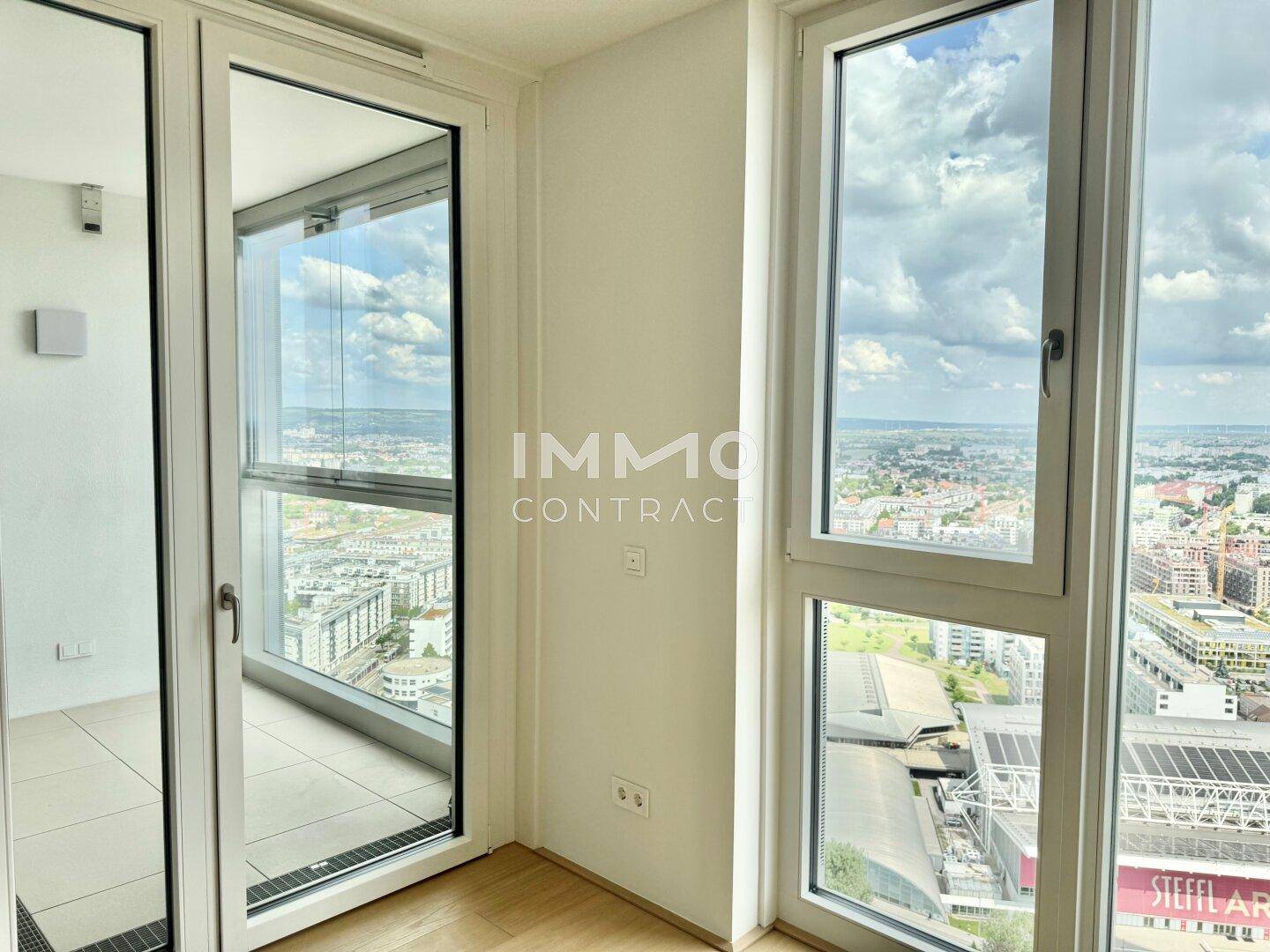 Helle Ecke mit großen Fenstern und Zugang zu einem Außenbereich, bietet weite Aussicht.