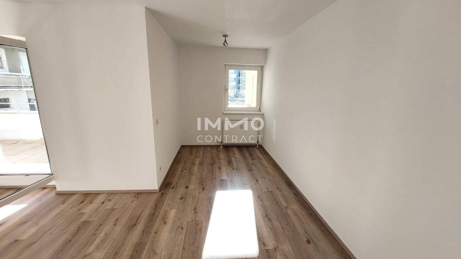 Lichtdurchfluteter Raum mit Laminatboden und Fenster, geeignet als Schlafzimmer oder Büro.