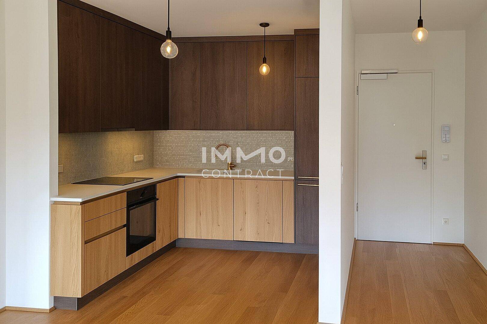 Moderne Einbauküche mit Holzfronten, integrierten Geräten und Parkettboden.
