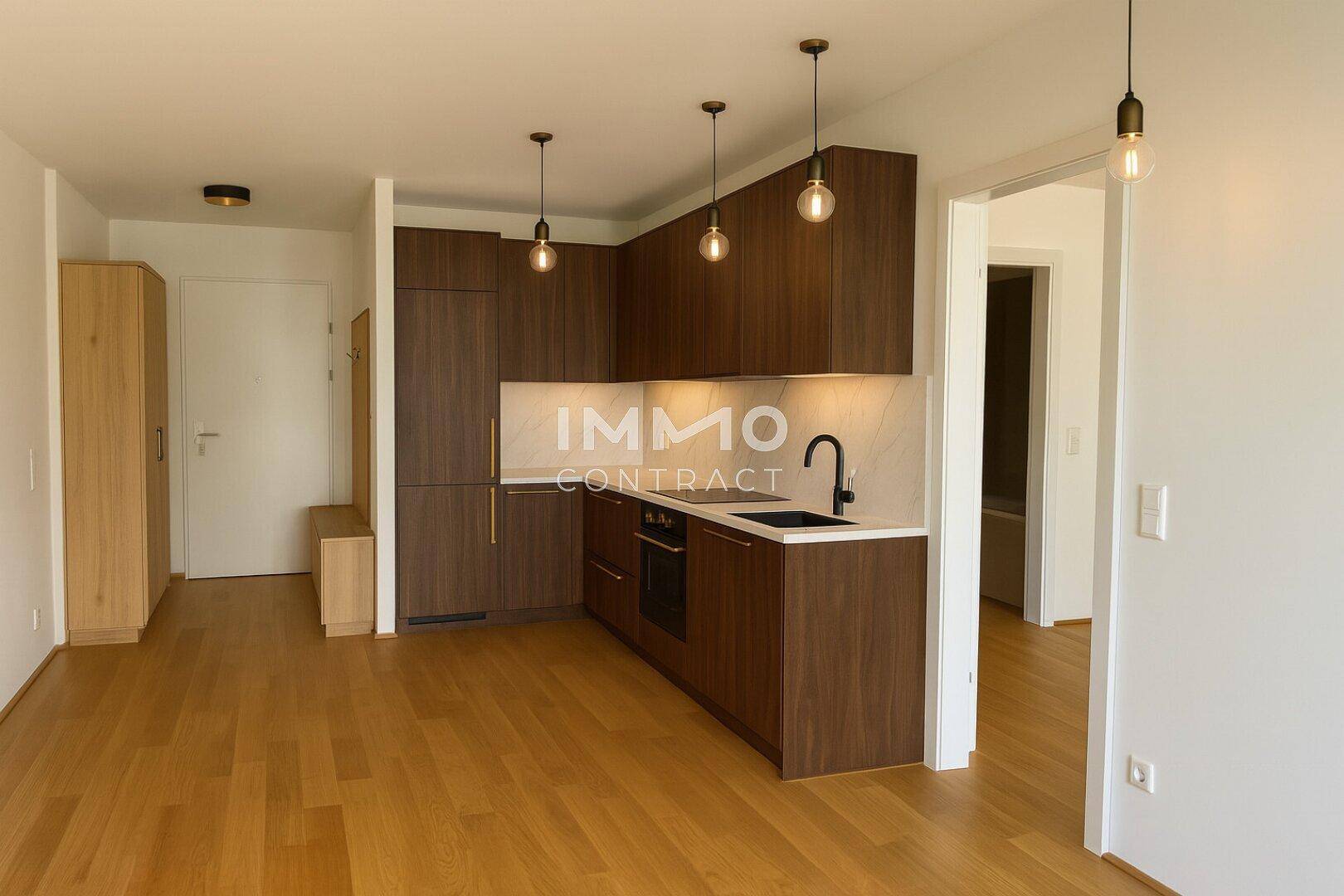 Moderne Küchenzeile mit dunklen Holzfronten, integrierten Geräten und Holzboden in offenem Wohnbereich.