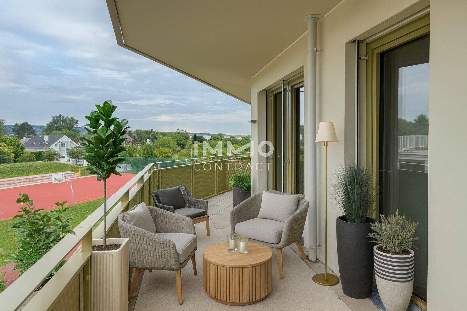 Geräumiger Balkon mit modernen Outdoor-Möbeln und weitem Blick ins Grüne.