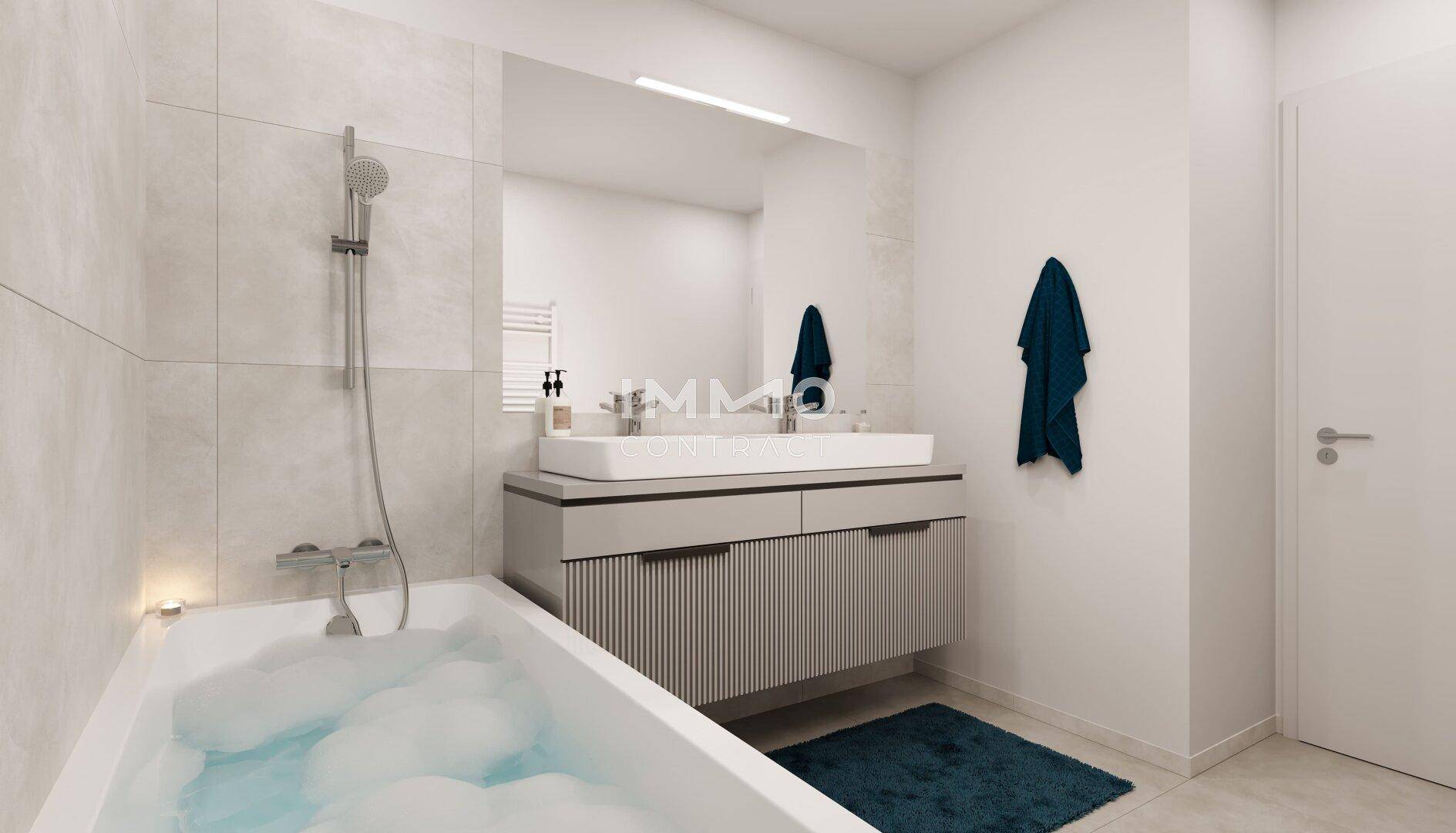 Modernes Badezimmer mit Badewanne, Dusche und Doppelwaschbecken in hellen Farbtönen.
