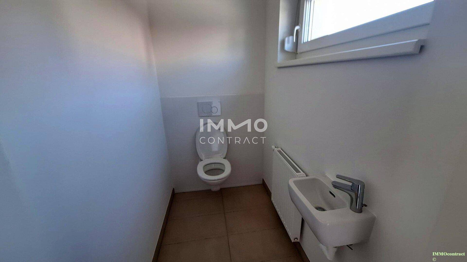 Kleines Gäste-WC mit Fenster, wandhängender Toilette und Handwaschbecken.