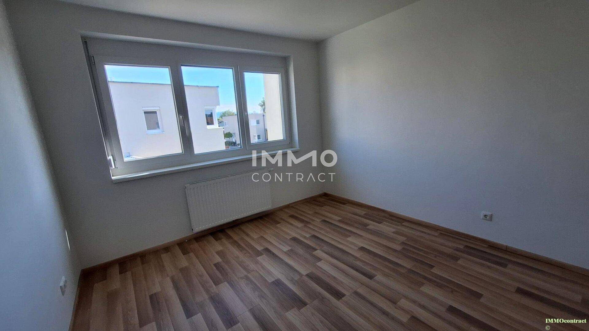 Geräumiges Zimmer mit Laminatboden und großem Fenster, ideal als Schlaf- oder Kinderzimmer.