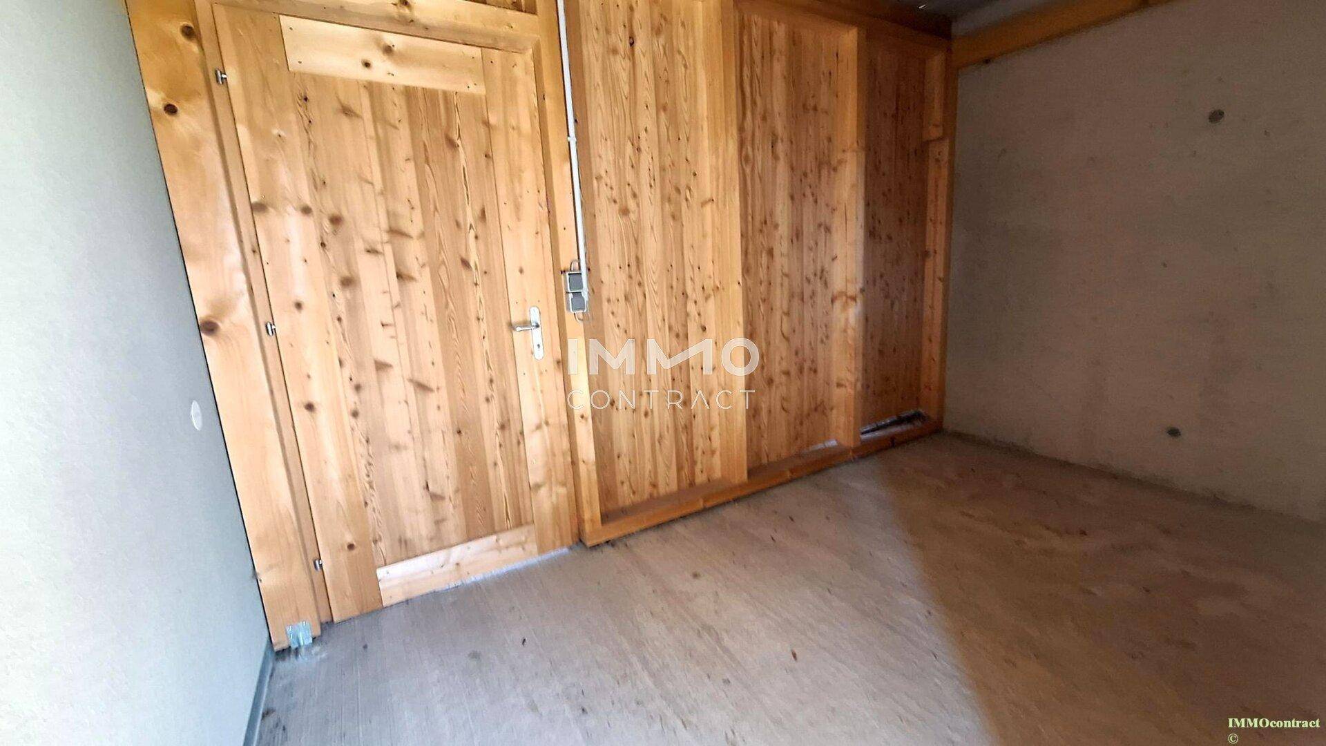 Innenansicht eines Abstellraums mit Holzwänden und Holztür.