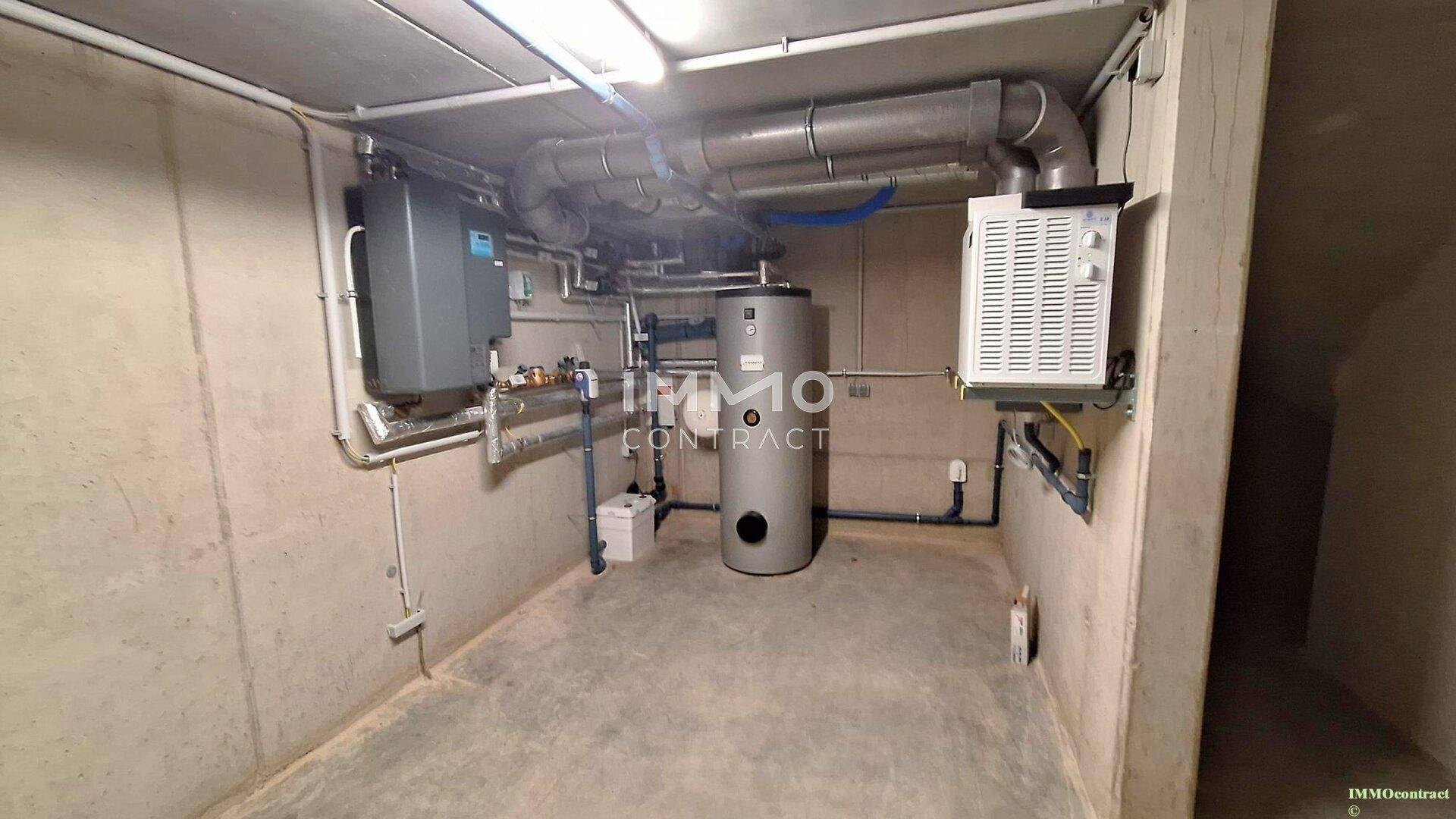 Technikraum im Keller mit Heizungsanlage und Warmwasserspeicher, funktional und sauber.