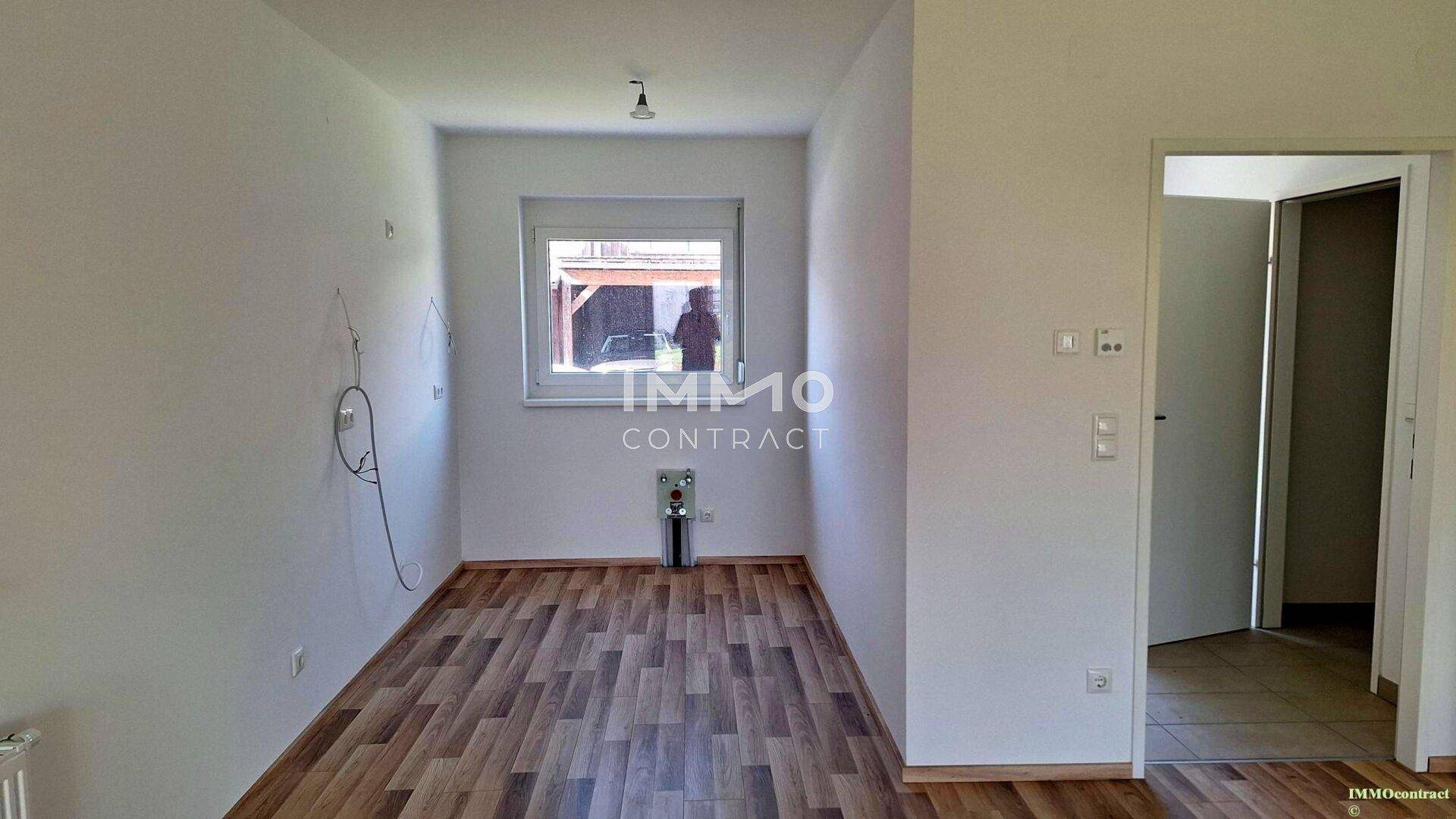 Raum mit Laminatboden und vorbereiteten Anschlüssen, ideal als Hauswirtschaftsraum oder Küche.