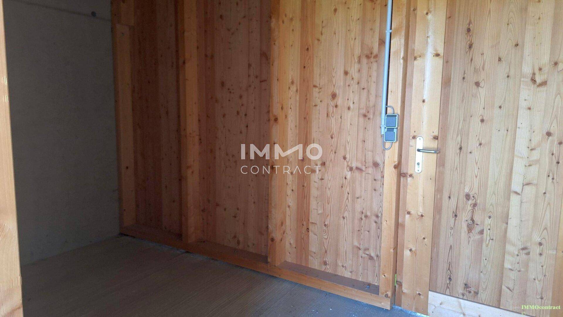 Abstellraum mit Holzverkleidung und einfacher Tür, ideal für Lagerzwecke.