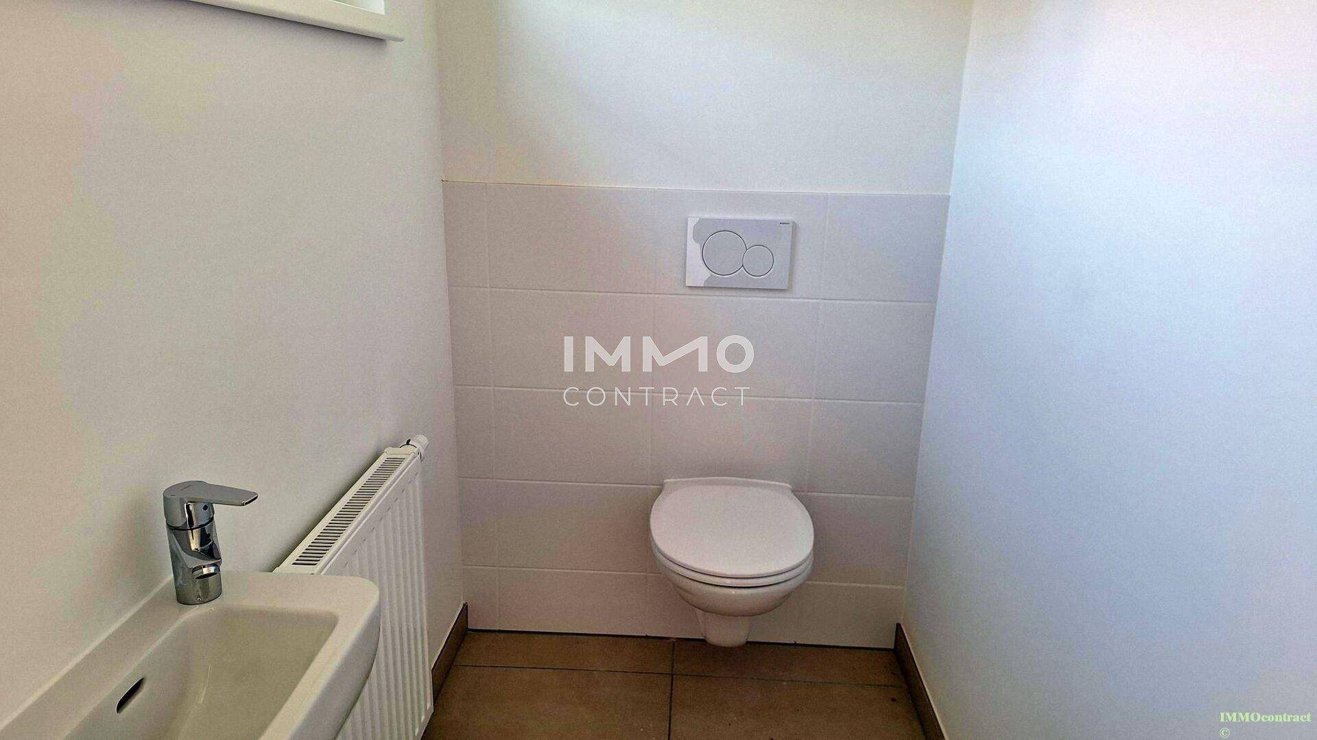 Separates Gäste-WC mit Wand-WC und kleinem Waschbecken, gefliestem Boden.