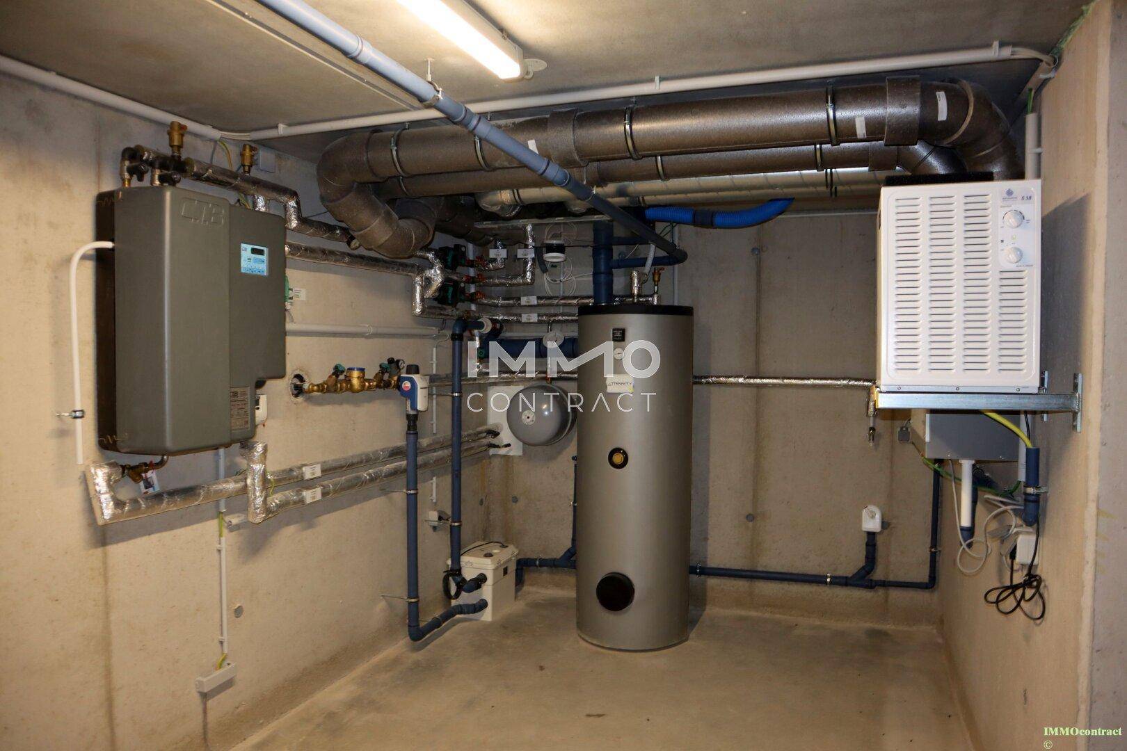 Technikraum im Keller mit Heizungsanlage und Warmwasserspeicher.