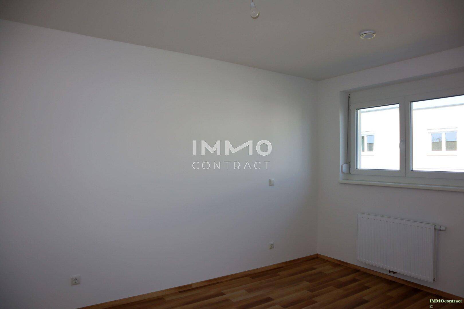 Helles Schlafzimmer mit Holzboden und Fenster, bereit zur individuellen Gestaltung.