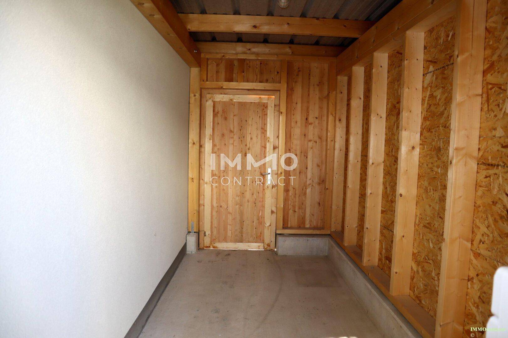 Abstellraum mit Holzverkleidung und Tür, bietet zusätzlichen Stauraum.