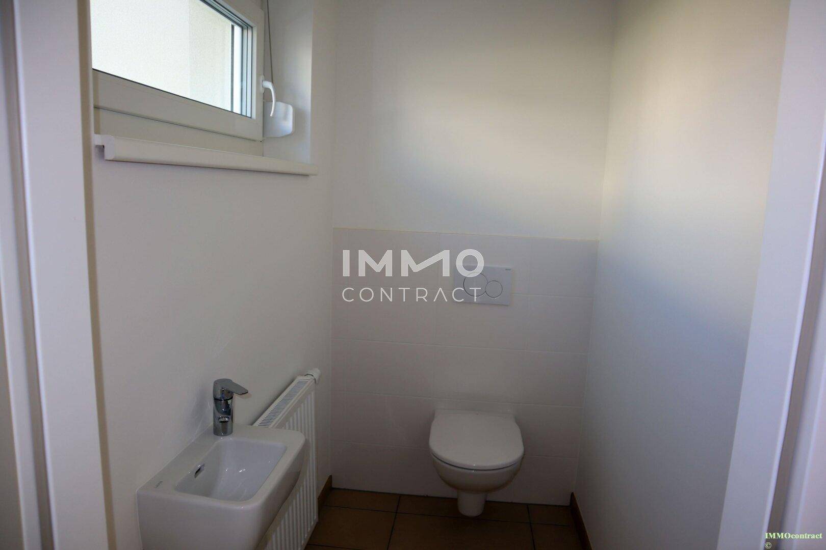 Modernes Gäste-WC mit wandhängendem WC, kleinem Waschbecken und Fenster.