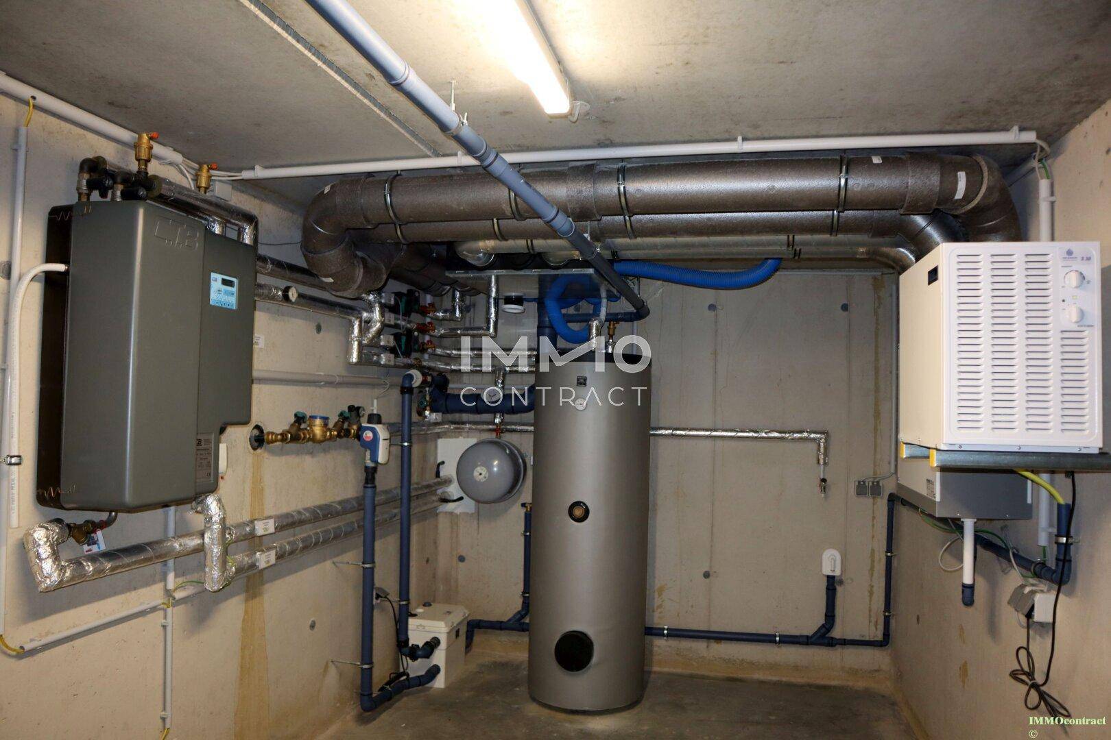 Technikraum im Keller mit Heizungsanlage und Warmwasserspeicher.