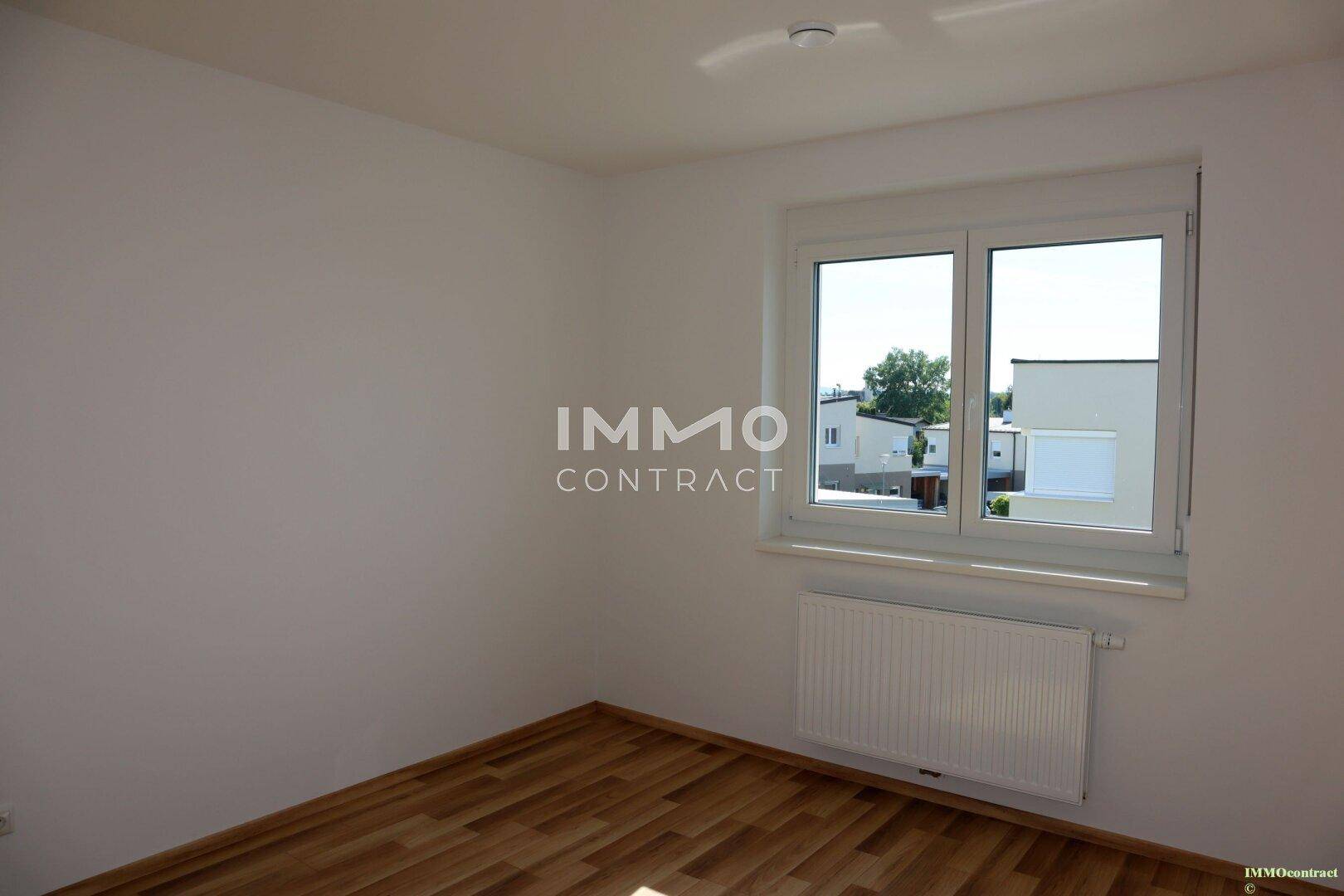 Schlafzimmer mit Laminatboden und Blick ins Grüne, ideal für Ruhe und Entspannung.