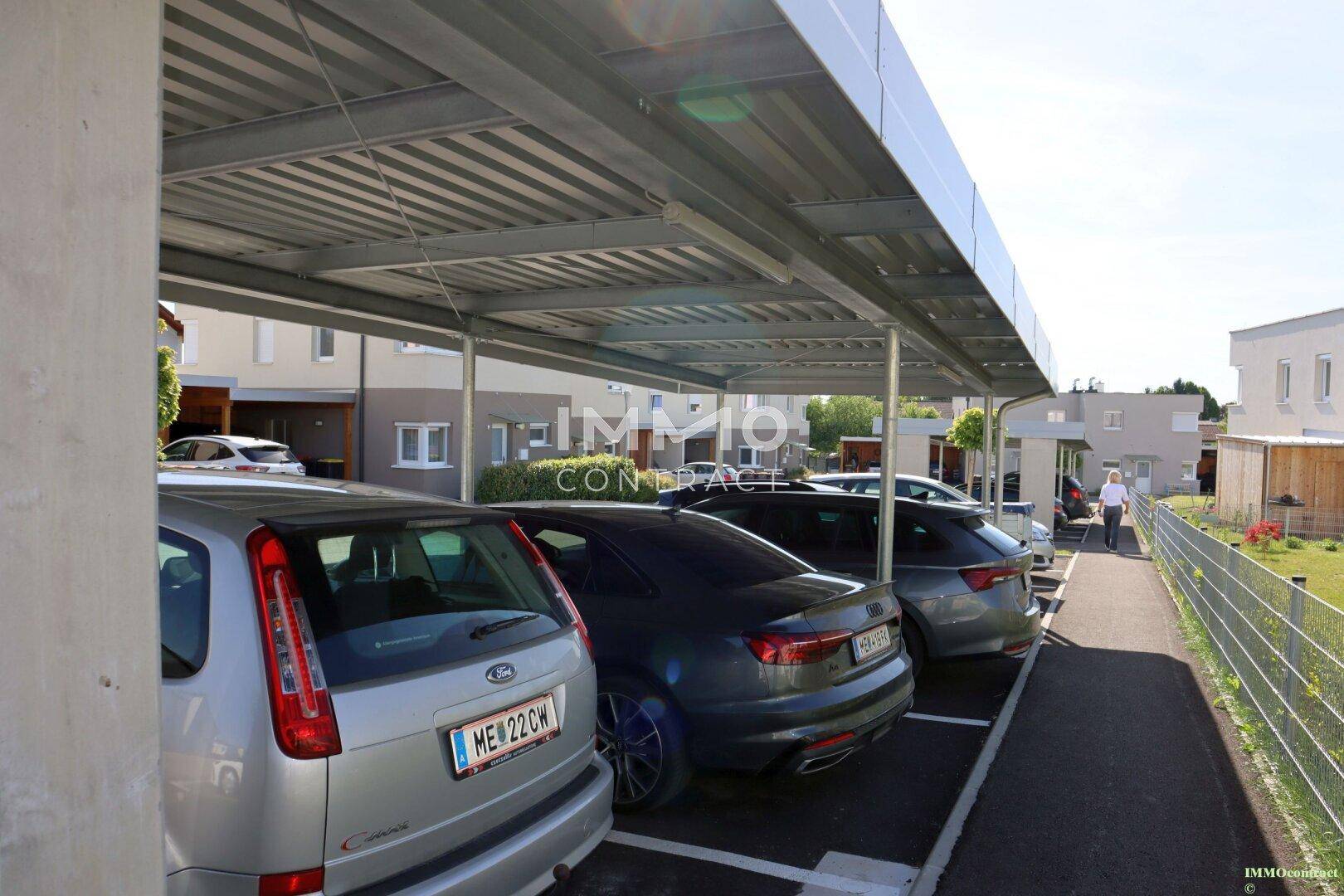 Überdachte Parkplätze für mehrere Fahrzeuge in der Wohnanlage.