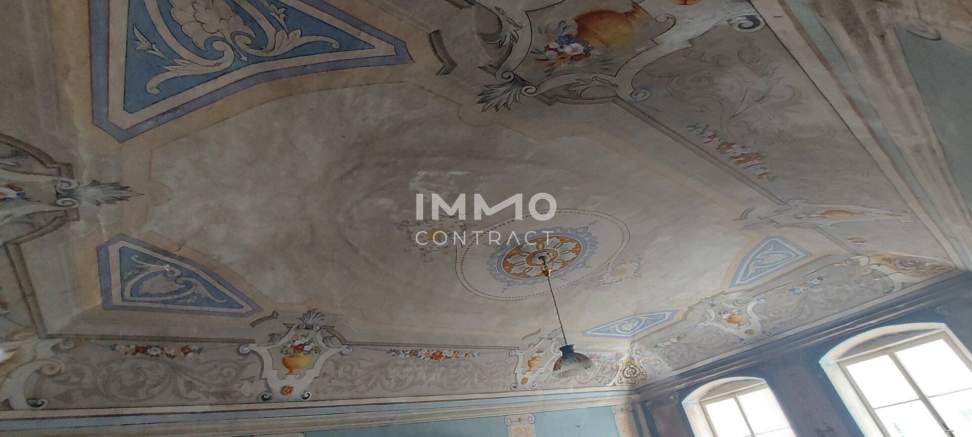 Detailansicht einer kunstvoll bemalten Decke mit historischen Ornamenten und Medaillons.
