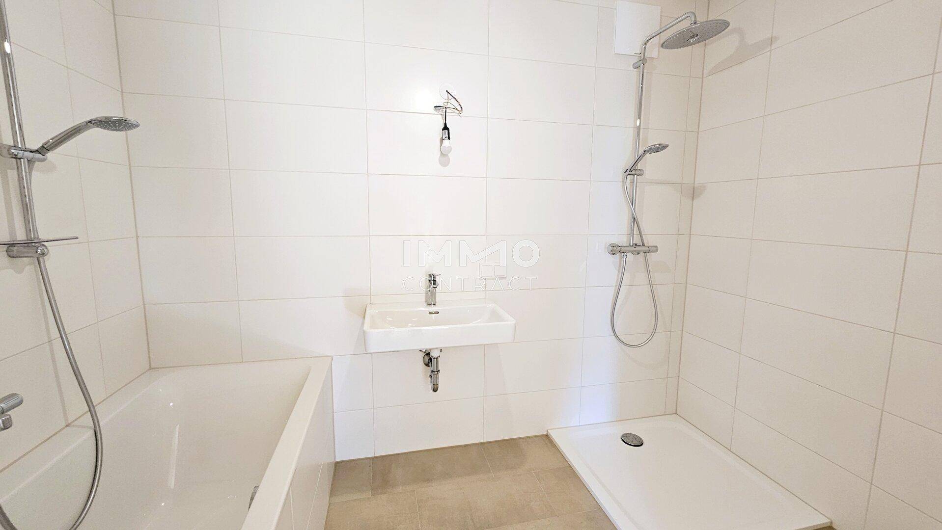 Modernes Badezimmer mit Badewanne, Dusche und weiß gefliesten Wänden.