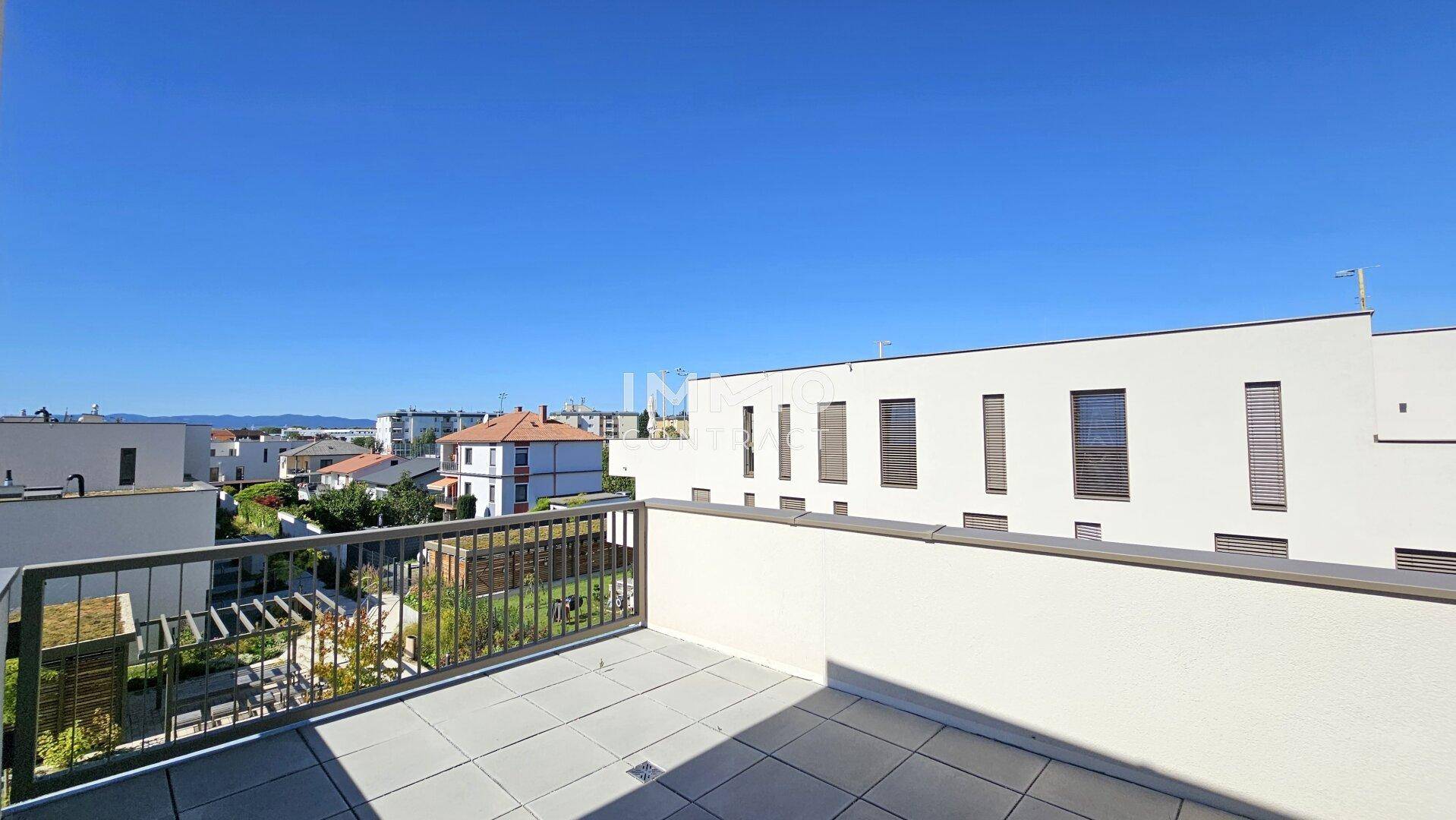 Weitläufige, geflieste Terrasse mit Metallgeländer und Panoramablick über die Dächer der Stadt.