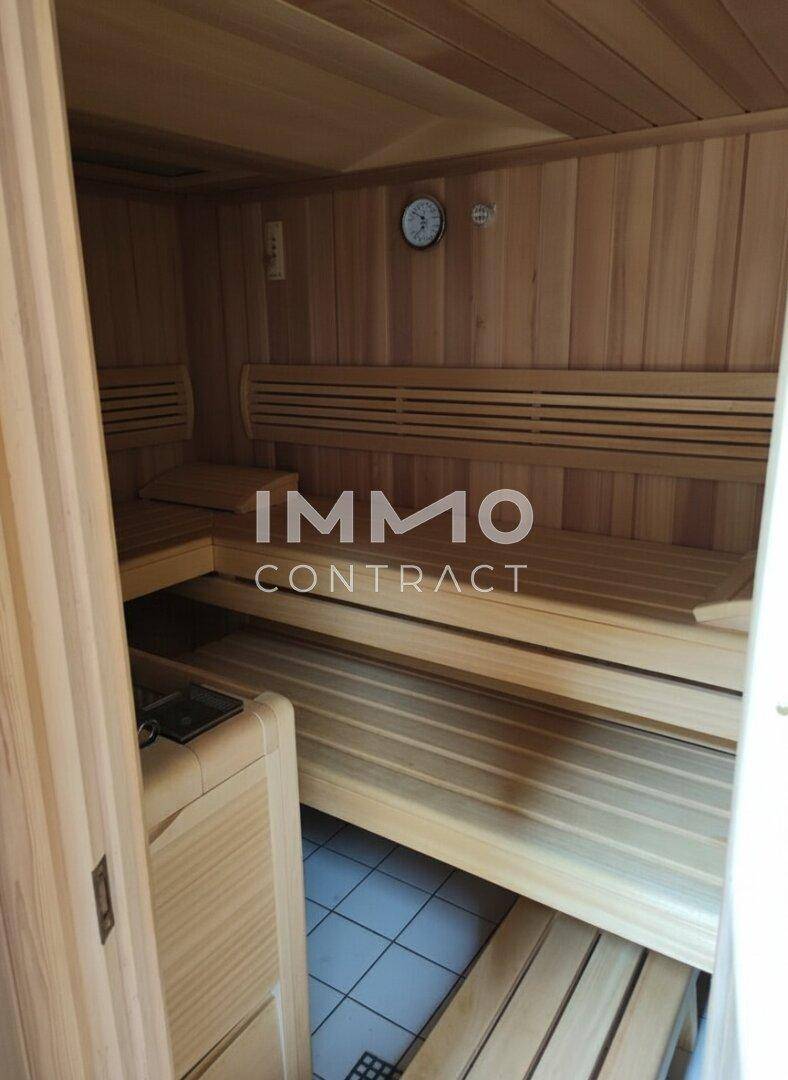 Traditionelle Holzsauna mit mehreren Bänken und einem Heizofen, ideal zur Entspannung und Erholung.
