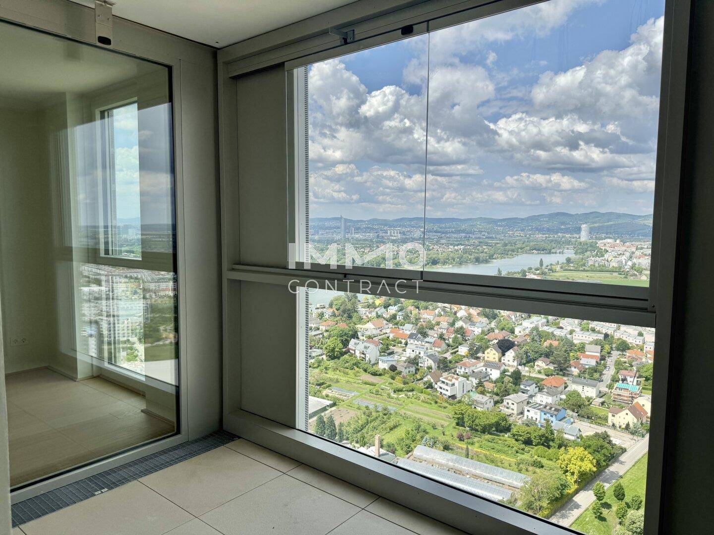 Verglaste Loggia mit Fliesenboden und weitem Panoramablick über die Stadt und die Donau.
