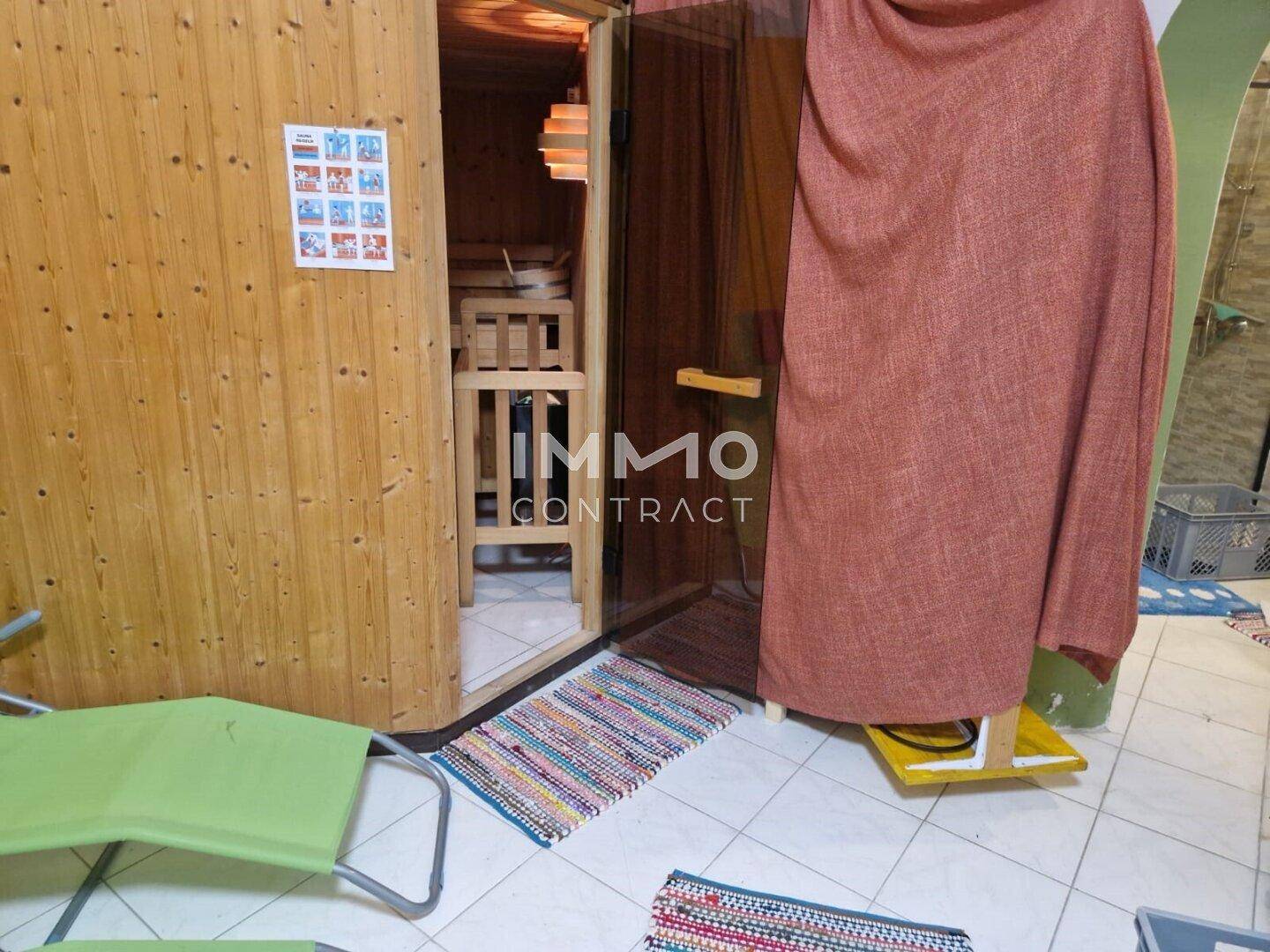 Innenbereich mit einer holzverkleideten Sauna und Entspannungsliegen.