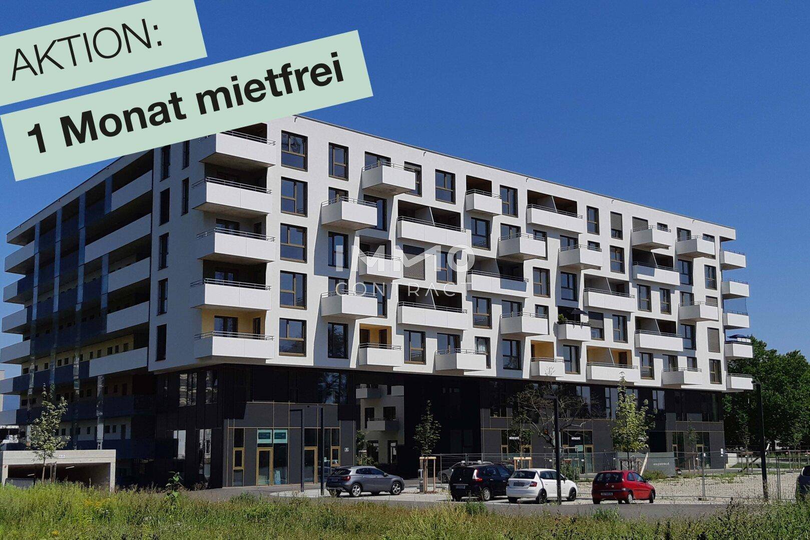 Weitläufige Ansicht eines modernen Apartmentgebäudes mit vielen Balkonen und großen Fenstern.