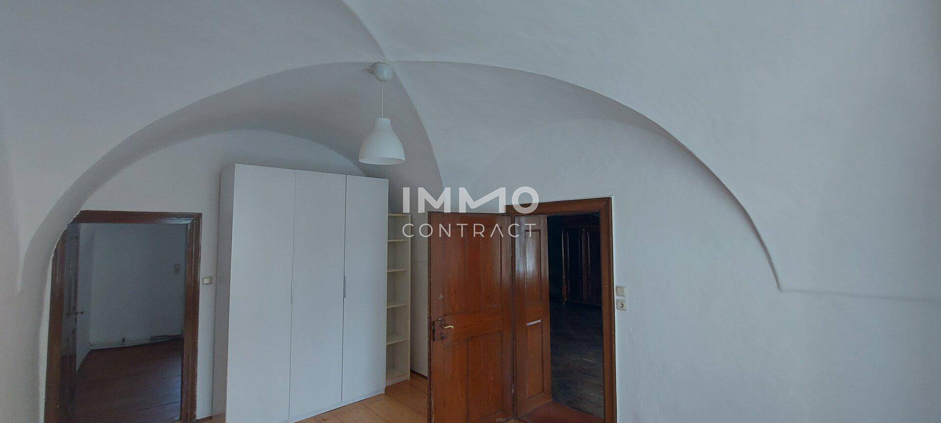 Zimmer mit weißer Gewölbedecke und Holztüren, bereit zur individuellen Gestaltung.