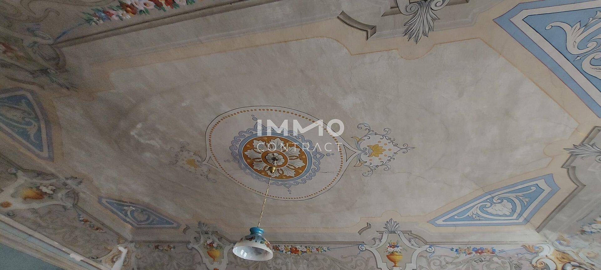 Nahaufnahme der detailreichen, bemalten Gewölbedecke mit zentralem Medaillon.