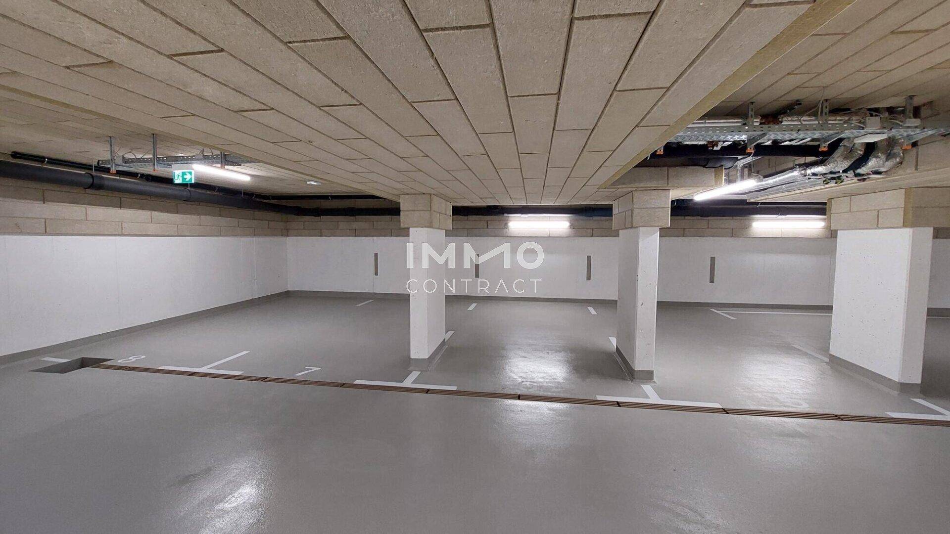 Saubere und gut beleuchtete Tiefgarage mit klaren Markierungen für Parkplätze.