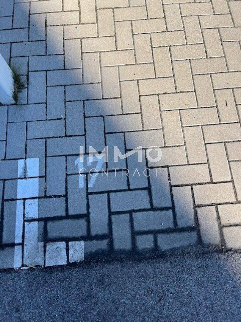 Nahaufnahme eines gepflasterten Parkplatzes mit der Nummer 17 auf dem Boden markiert.