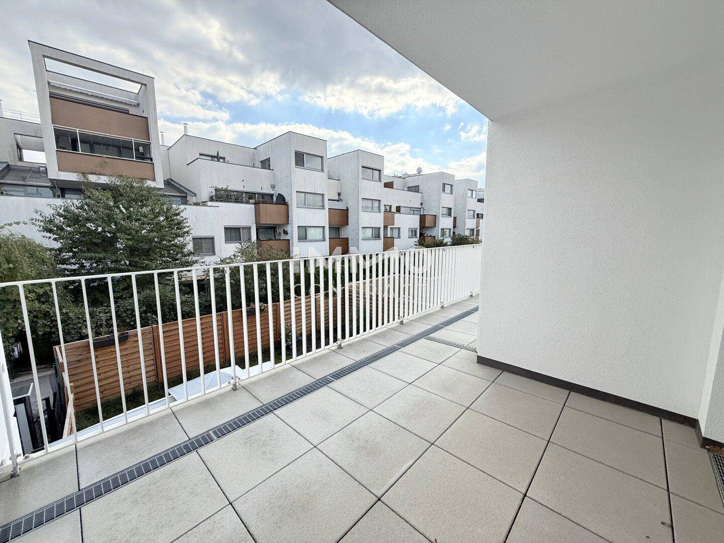 Balkon mit Blick auf die umliegenden Wohngebäude und viel Grün.