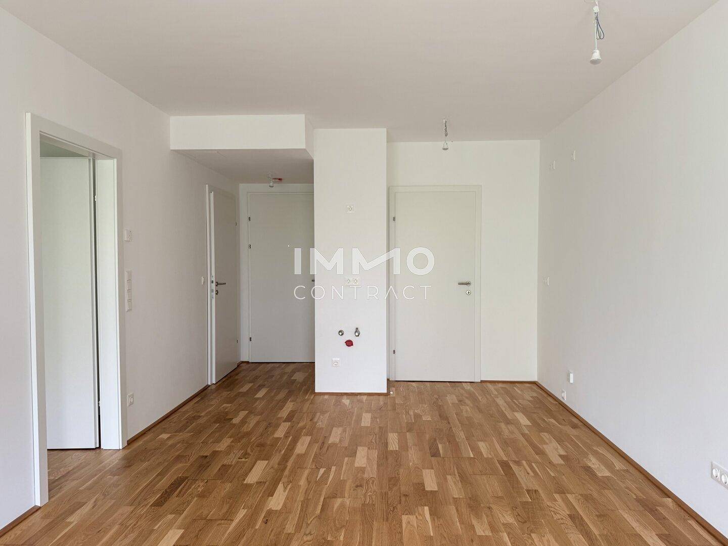 Heller Flur mit Parkettboden und mehreren Türen, der verschiedene Räume verbindet.