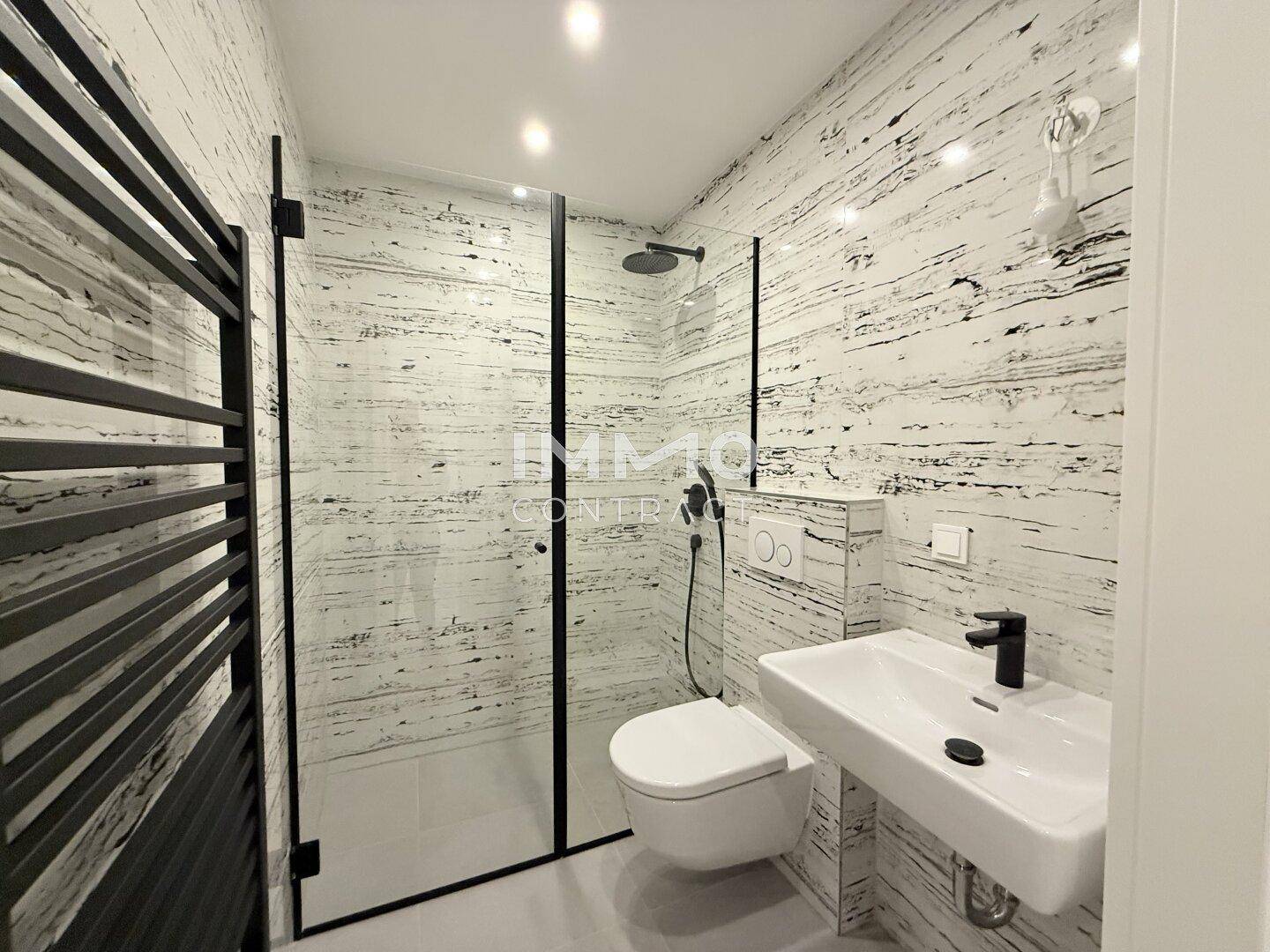 Modernes Badezimmer mit begehbarer Dusche, wandhängendem WC und stilvollen Wandfliesen.