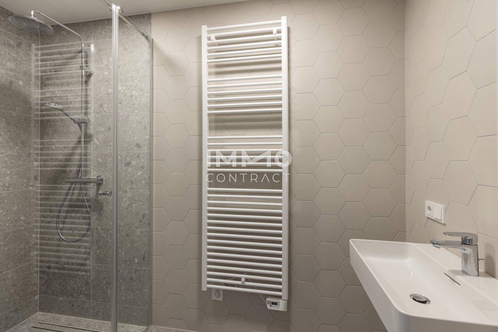 Modernes Badezimmer mit begehbarer Dusche, Einzelwaschbecken und Handtuchheizkörper.