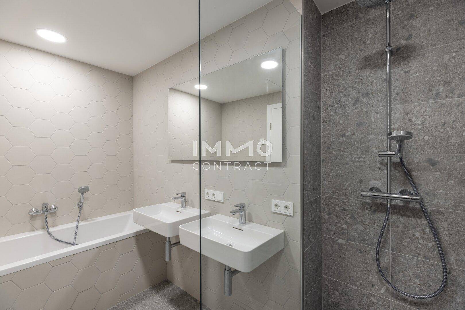 Modernes Badezimmer mit Doppelwaschbecken, Badewanne und separater Dusche.