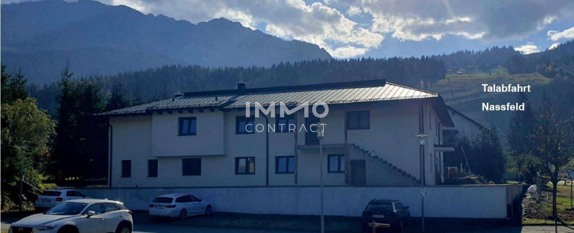 Wohngebäude in alpiner Umgebung mit Blick auf die Berge und Parkmöglichkeiten.