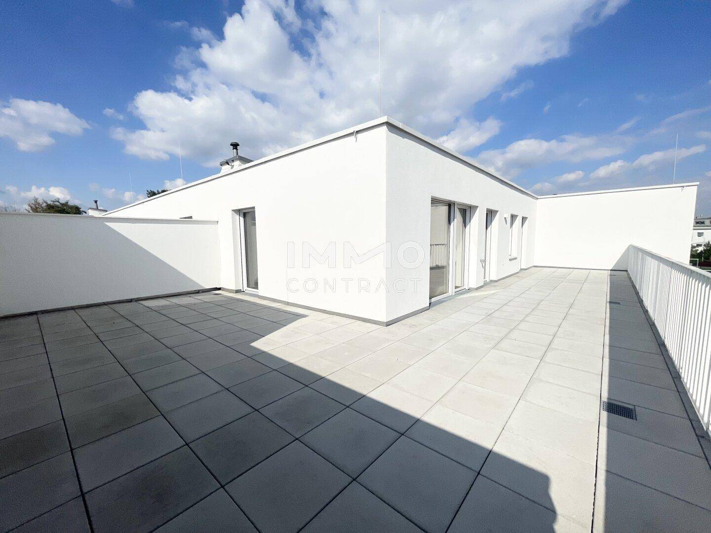 Weitläufige, unmöblierte Dachterrasse mit klaren Linien und viel Sonnenlicht, bereit für individuelle Gestaltung.