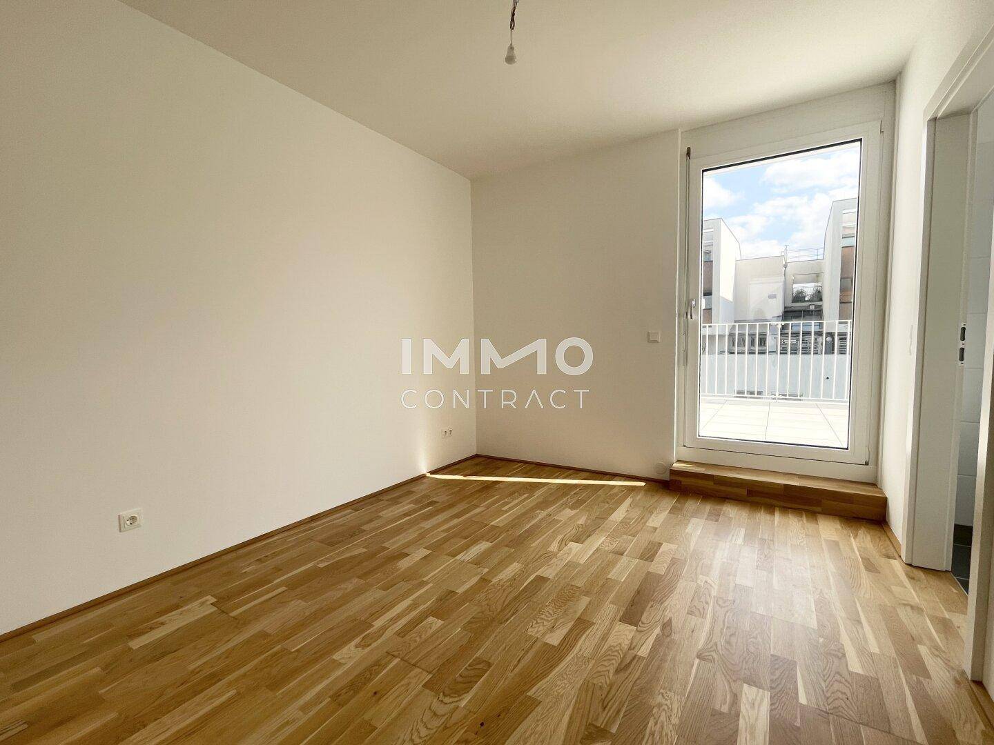 Geräumiges Zimmer mit direktem Zugang zur Terrasse und hellem Parkettboden, ideal als Schlaf- oder Arbeitszimmer.