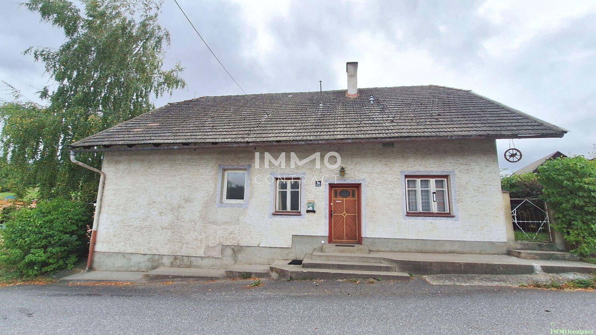 Vorderansicht eines traditionellen Hauses mit Satteldach und einfacher Fassade.