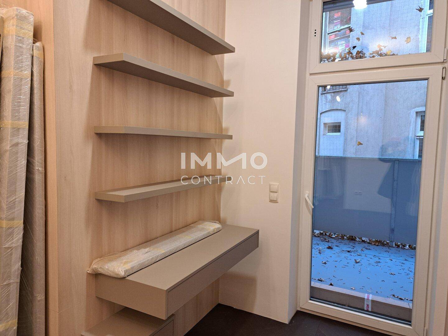 Helle Regale und eine Ablagefläche neben einem Fenster, ideal für Dekoration oder Arbeitsbereich.