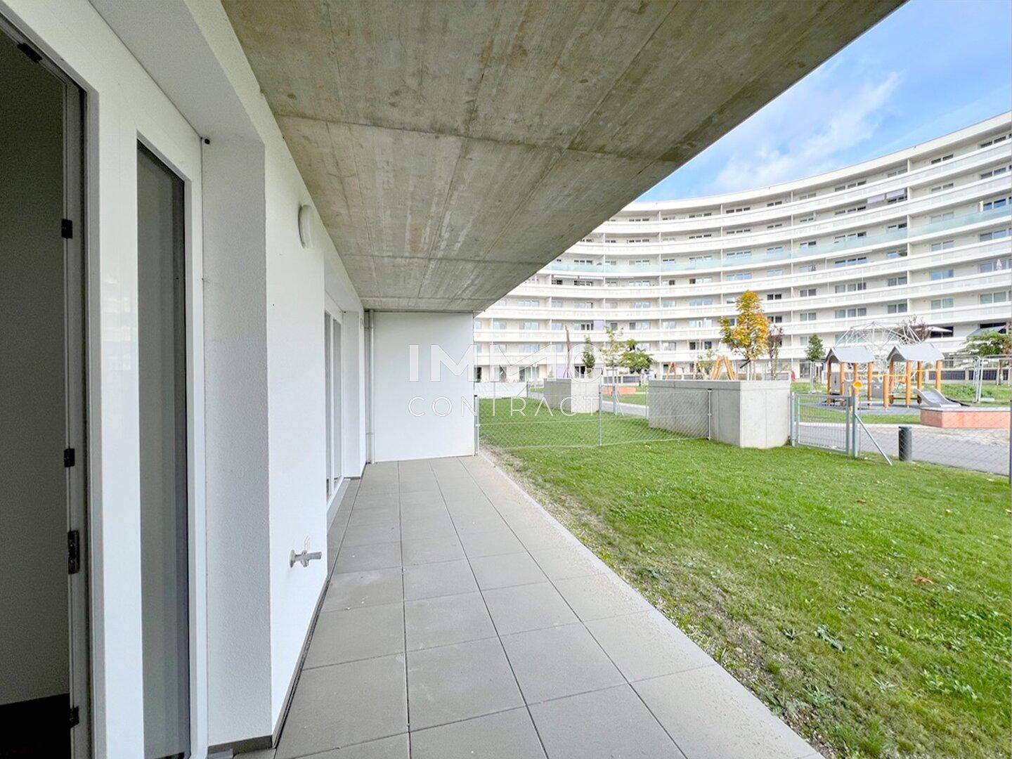 Geräumige Terrasse im Erdgeschoss mit Blick auf den Gemeinschaftsgarten und einen Spielplatz.