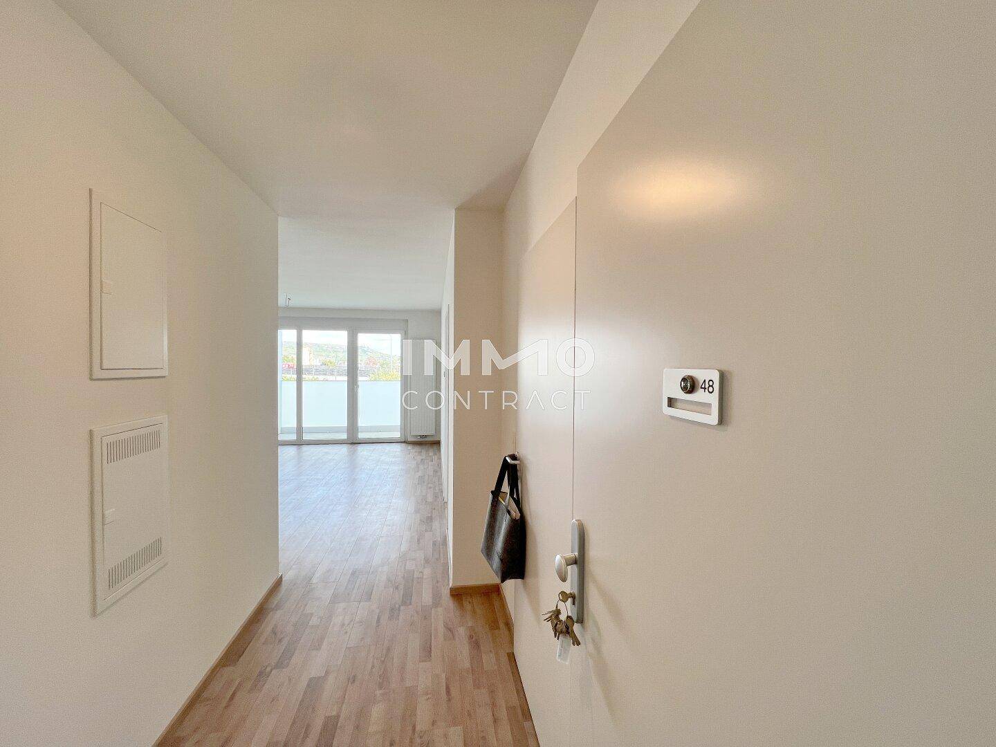 Heller Eingangsbereich mit Laminatboden und offenem Blick in den Wohnbereich.