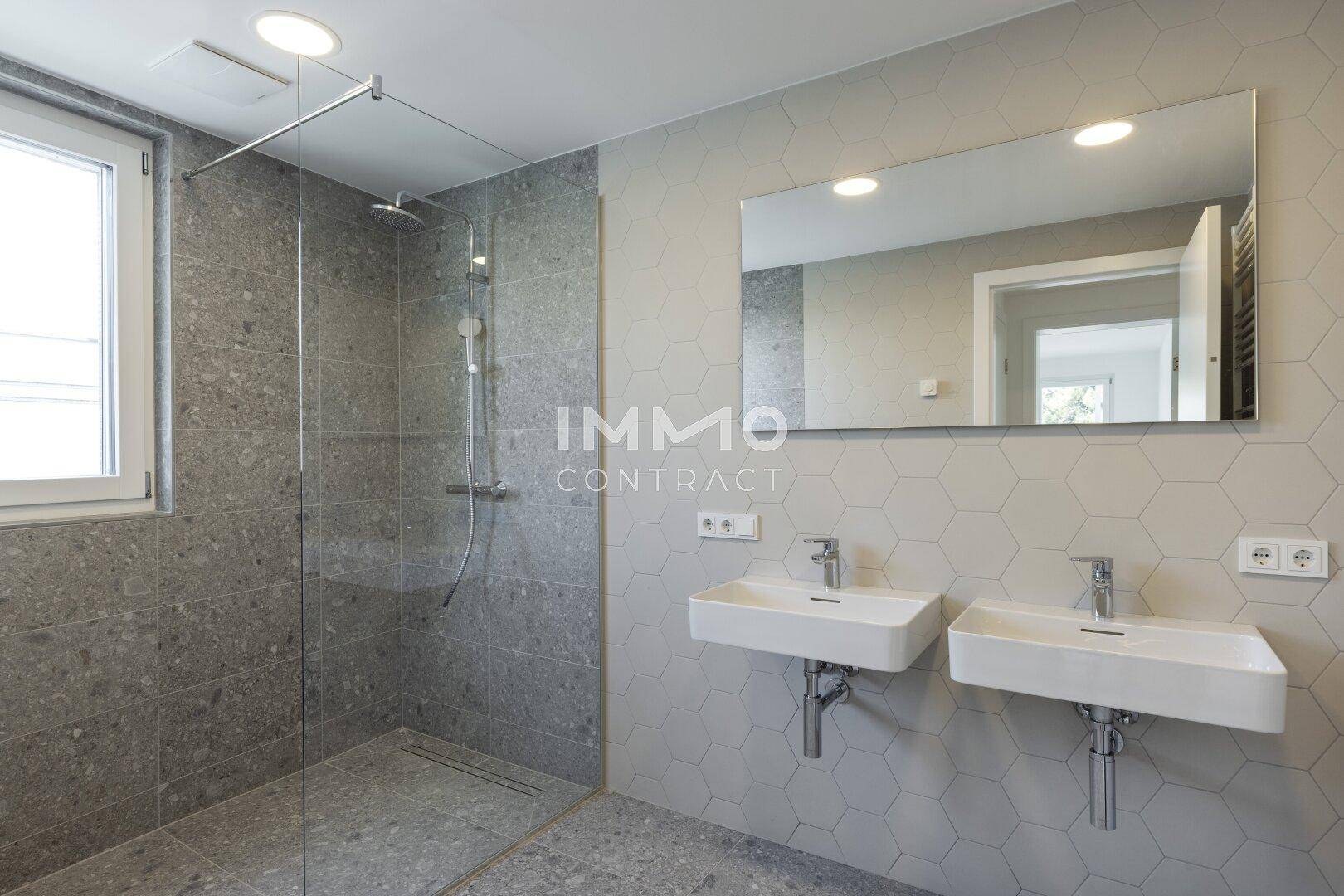 Modernes Badezimmer mit begehbarer Dusche, Doppelwaschbecken und Fenster.