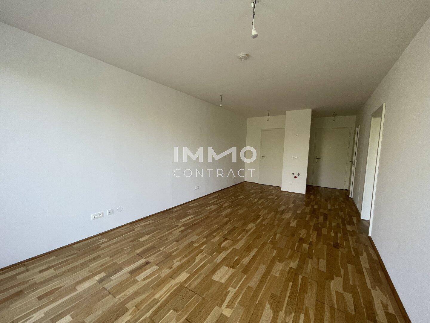 Geräumiges, unmöbliertes Zimmer mit hellem Parkettboden und weißen Wänden, ideal für Wohnzwecke.