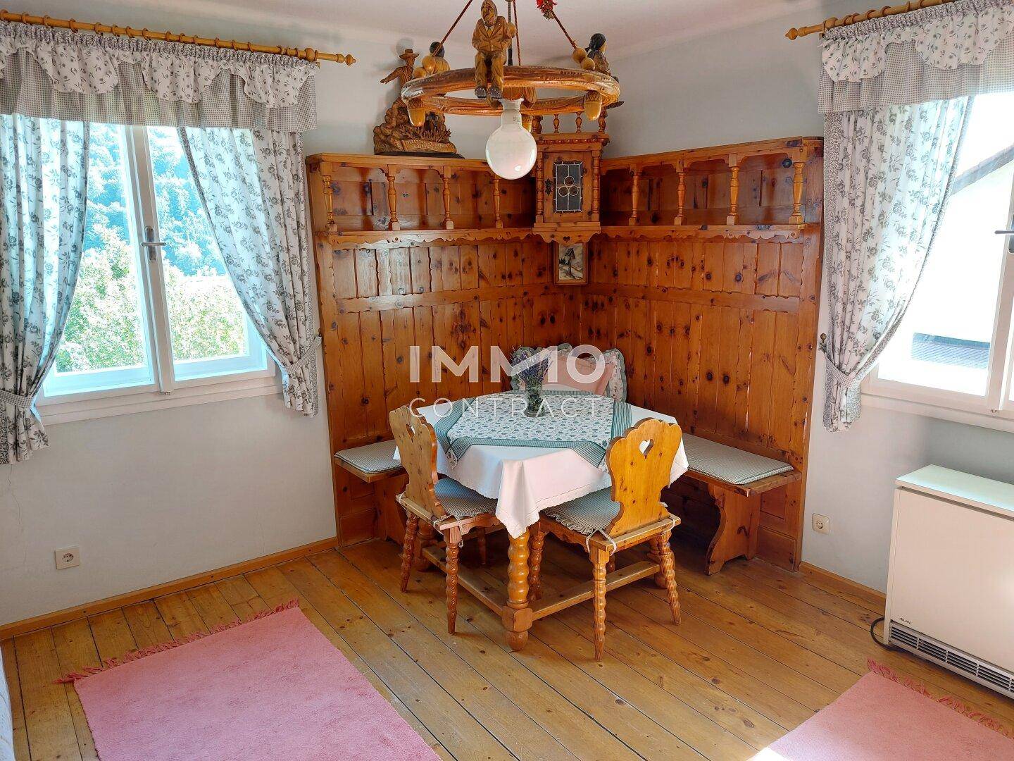 Traditioneller Essbereich mit Eckbank, Holztisch und Stühlen, umgeben von Holzvertäfelung.