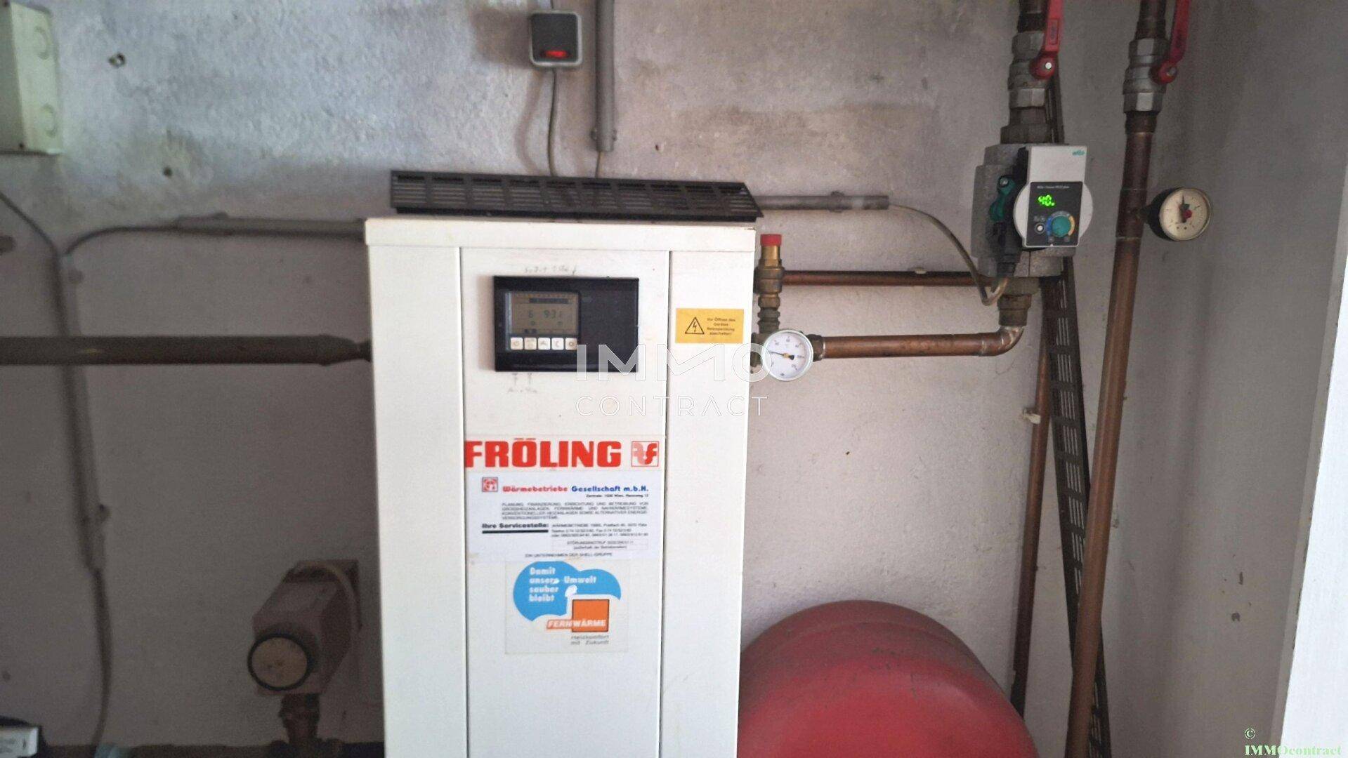 Heizraum mit einem modernen Froling Heizsystem und sichtbaren Rohren.