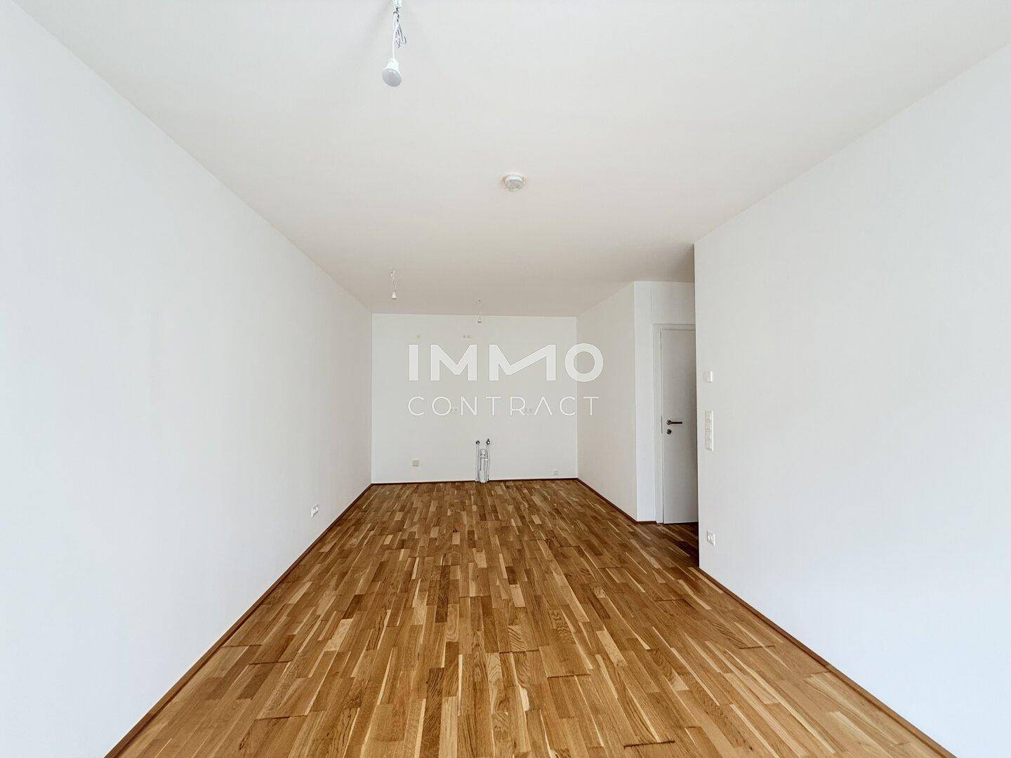 Leerer Raum mit Parkettboden und Anschlüssen an der Wand, vielseitig nutzbar.