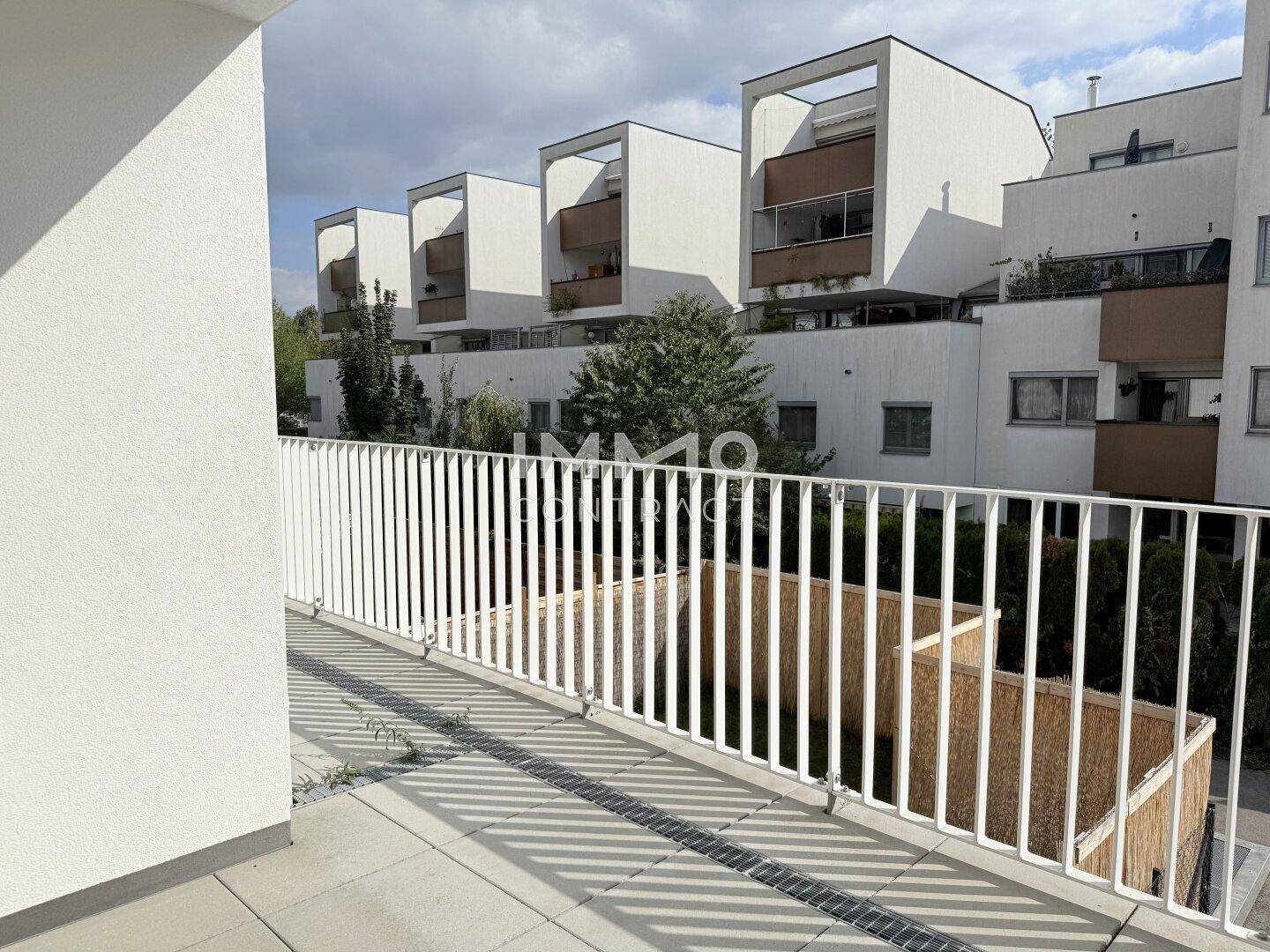 Geräumiger Balkon mit modernem Geländer und Blick auf die umliegenden Wohngebäude.